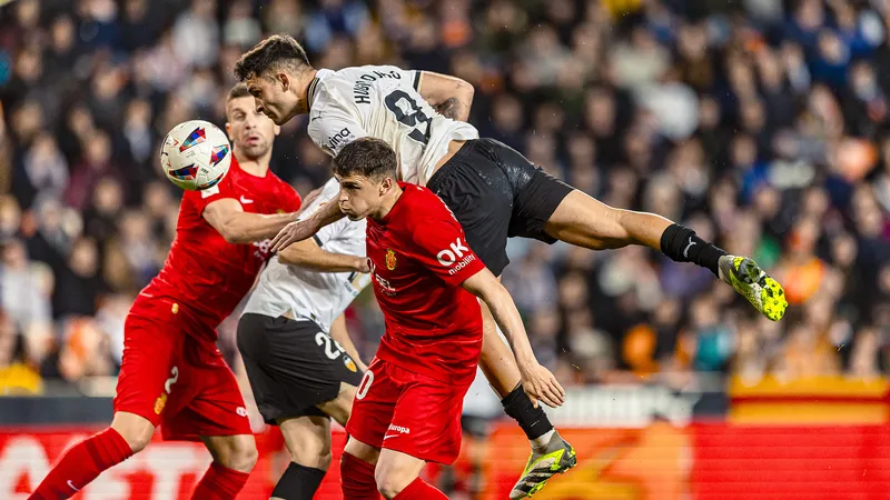 Cầu thủ của Valencia vượt qua hàng phòng ngự của Mallorca trong trận đấu bóng đá sôi động Cầu thủ của Valencia vượt qua hàng phòng ngự của Mallorca trong trận đấu bóng đá sôi động