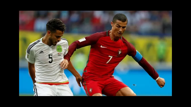 Cầu thủ Mexico và Bồ Đào Nha tranh chấp bóng trên sân cỏ Cầu thủ Mexico và Bồ Đào Nha tranh chấp bóng trên sân cỏ